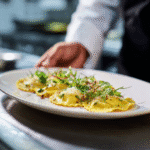 Gordon Ramsay egg yolk ravioli plated professionally with herbs and cheese